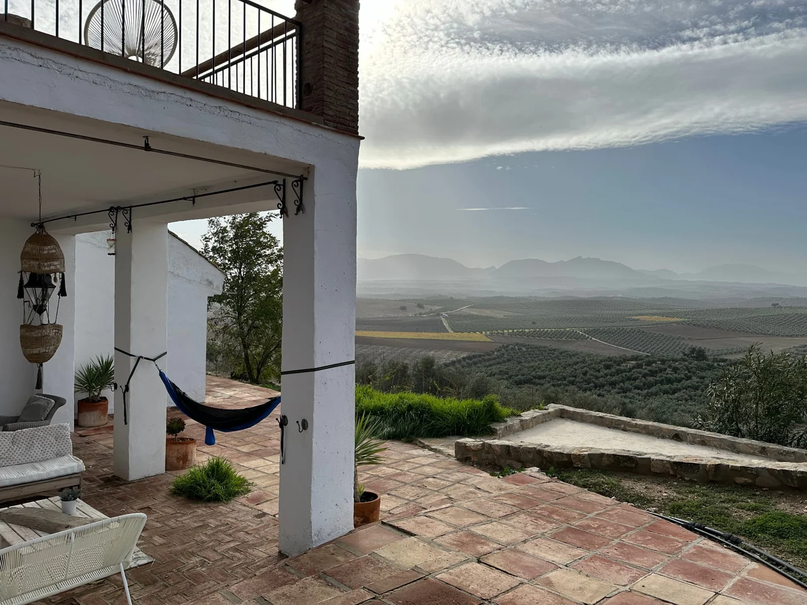 Covered terrace and hammock overlooking olive groves and distant mountains