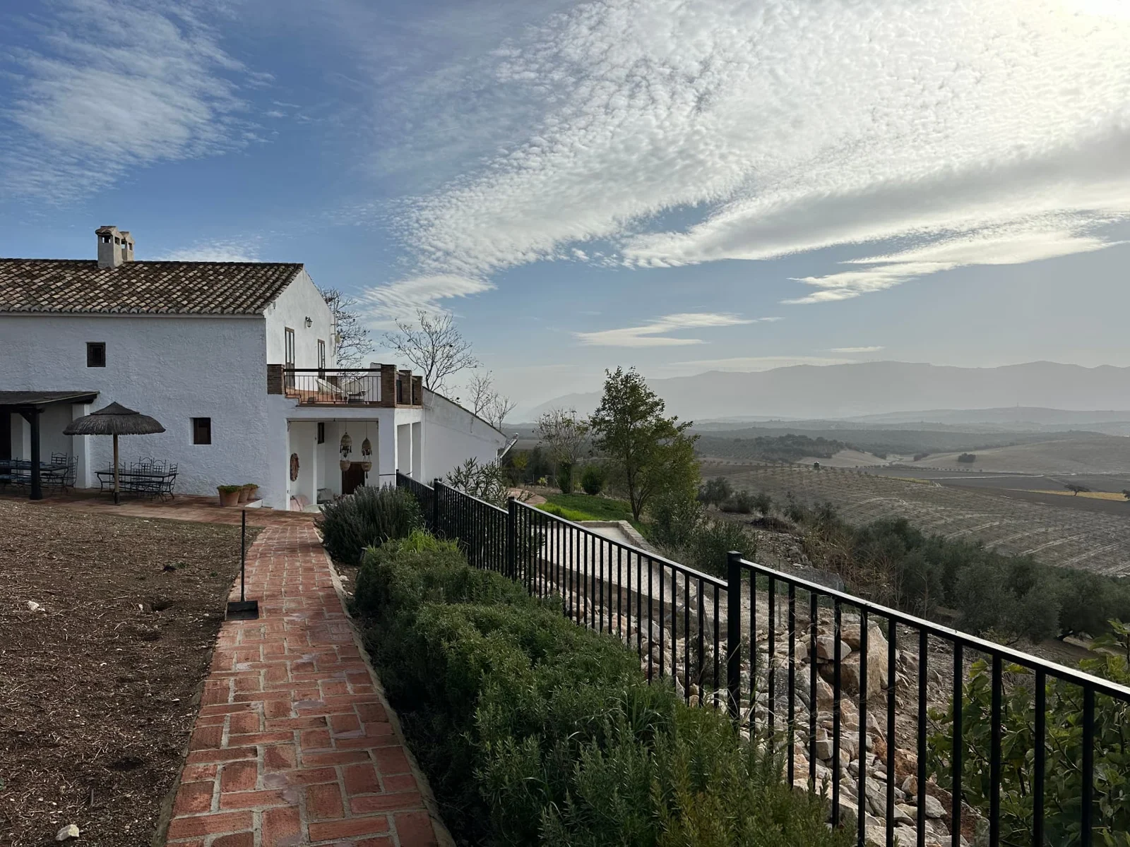 A brick walkway beside the house with sweeping views over the countryside