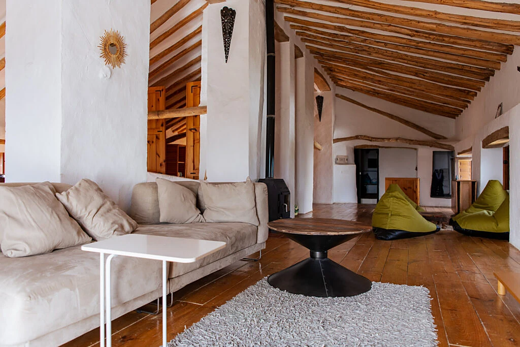 Spacious attic lounge with wooden beams, sofa and beanbags