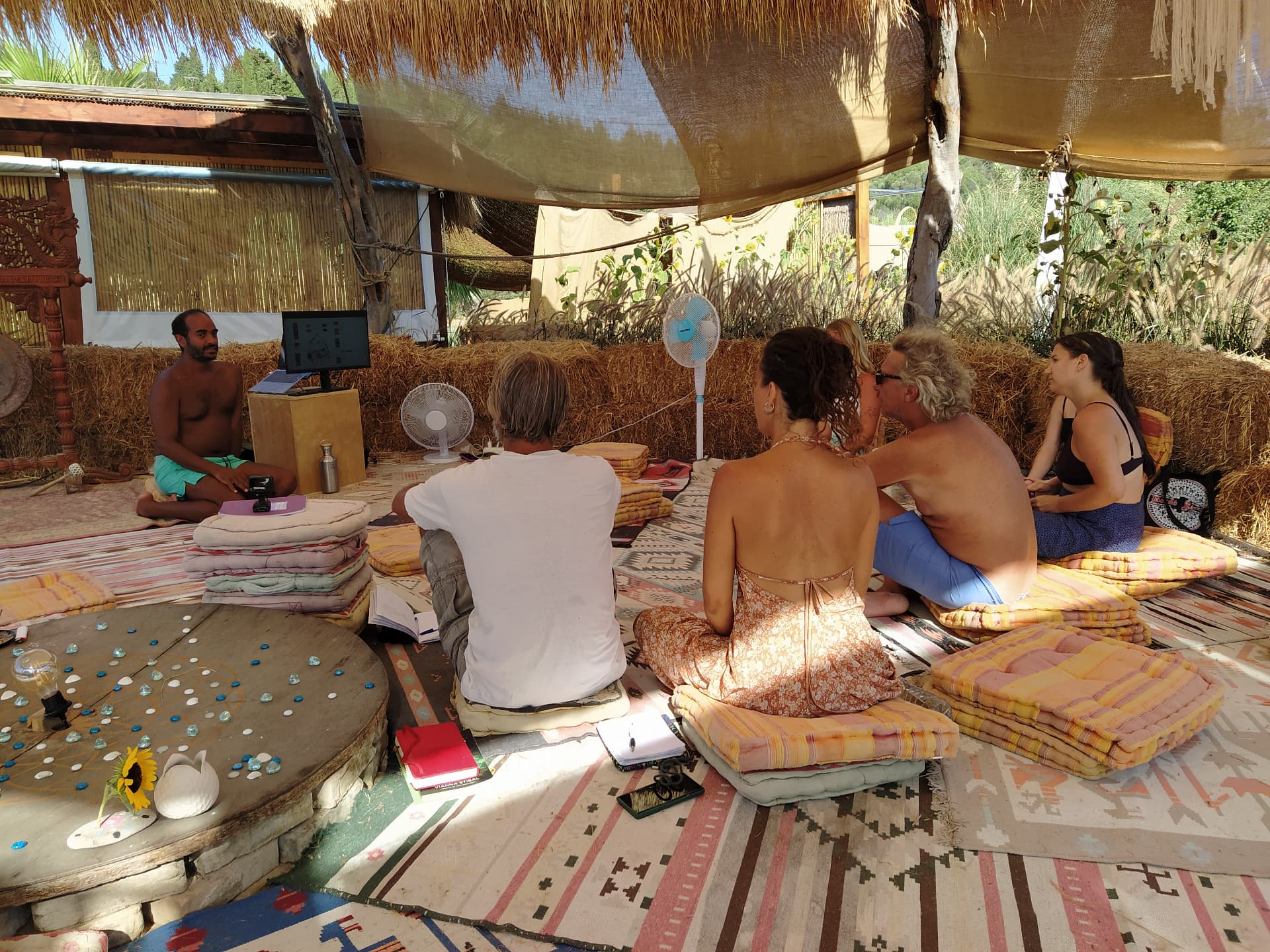 A small group gathered for an outdoor lesson under a shaded canopy